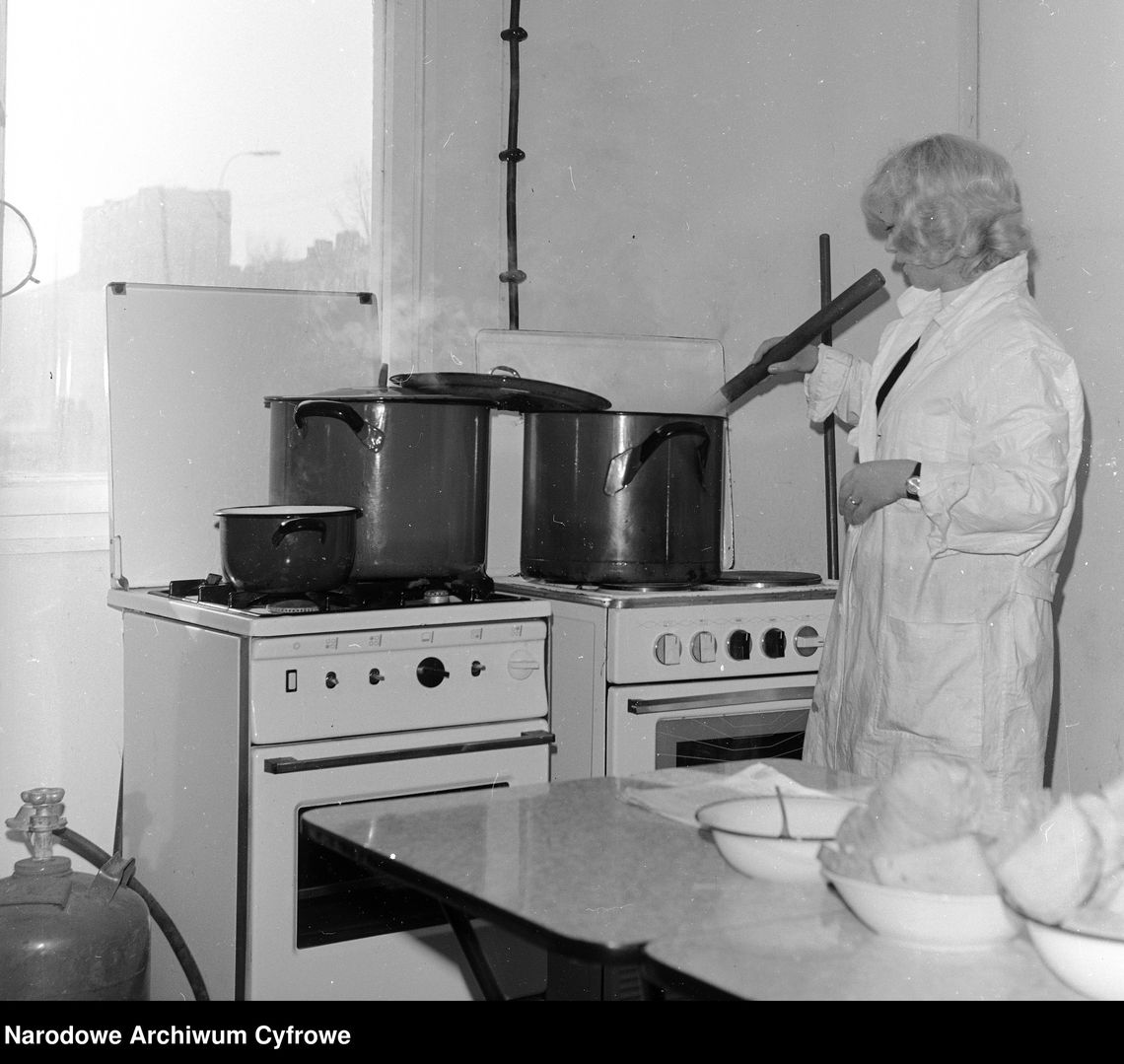 Kroniki miasta. Chełmska reglamentacja butli z gazem. Długa kolejka na zamówienia w 1970 roku Gotowanie posiłku dla robotników. Z lewej przy kuchence butla gazowa. Warszawa, rok 1974
